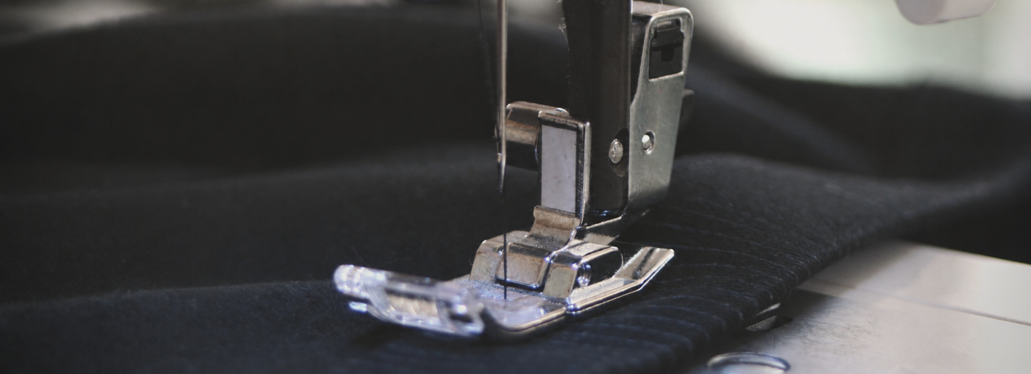 ALP manufacturing hero image showing a sewing machine working on black material.