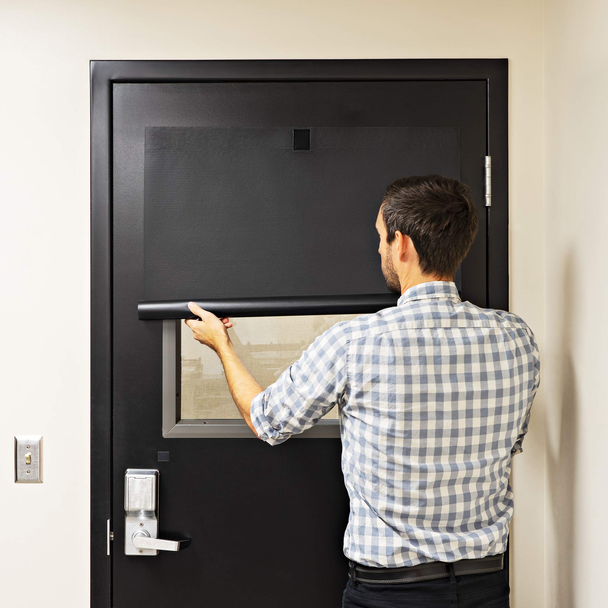 Person demonstrating ALP lockdown shade on a classroom door.